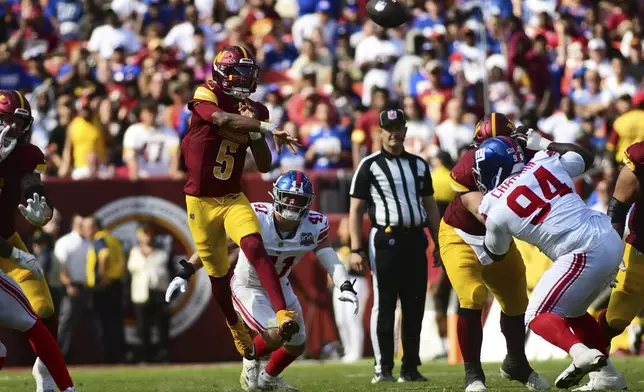 Washington Commanders quarterback Jayden Daniels (5) throws a pass against the New York Giants during the second half of an NFL football game in Landover, Md., Sunday, Sept. 15, 2024. (AP Photo/Steve Ruark)