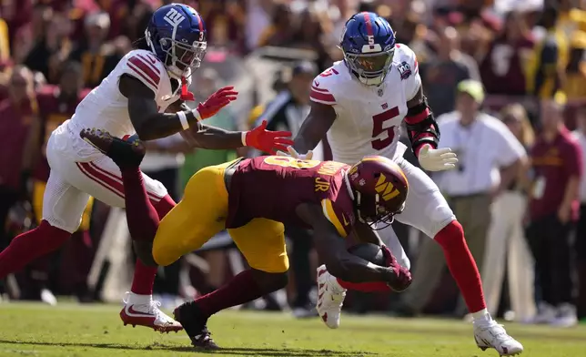 Washington Commanders running back Brian Robinson Jr. (8) is tackled by New York Giants linebacker Kayvon Thibodeaux (5) after a run during the second half of an NFL football game in Landover, Md., Sunday, Sept. 15, 2024. (AP Photo/Matt Slocum)