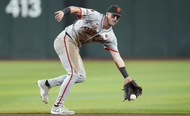 San Francisco Giants shortstop Tyler Fitzgerald makes a glove stop on an infield single by Arizona Diamondbacks' Josh Bell during the ninth inning of a baseball game Tuesday, Sept. 24, 2024, in Phoenix. (AP Photo/Ross D. Franklin)