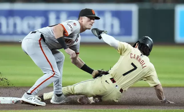 Arizona Diamondbacks' Corbin Carroll (7) steals second base as San Francisco Giants shortstop Tyler Fitzgerald applies the late tag during the first inning of a baseball game Tuesday, Sept. 24, 2024, in Phoenix. (AP Photo/Ross D. Franklin)