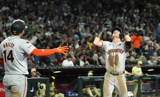 San Francisco Giants' Tyler Fitzgerald, right, celebrates his two-run home run against the Arizona Diamondbacks as Giants' Patrick Bailey (14) looks on during the fifth inning of a baseball game Tuesday, Sept. 24, 2024, in Phoenix. (AP Photo/Ross D. Franklin)