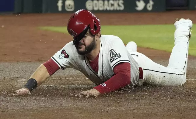 Arizona Diamondbacks' Eugenio Suárez scores a run against the San Francisco Giants during the second inning of a baseball game Wednesday, Sept. 25, 2024, in Phoenix. (AP Photo/Ross D. Franklin)