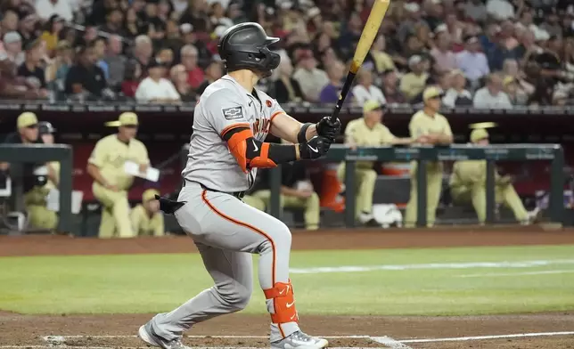 San Francisco Giants' Michael Conforto watches the flight of his three-run home run against the Arizona Diamondbacks during the third inning of a baseball game Tuesday, Sept. 24, 2024, in Phoenix. (AP Photo/Ross D. Franklin)