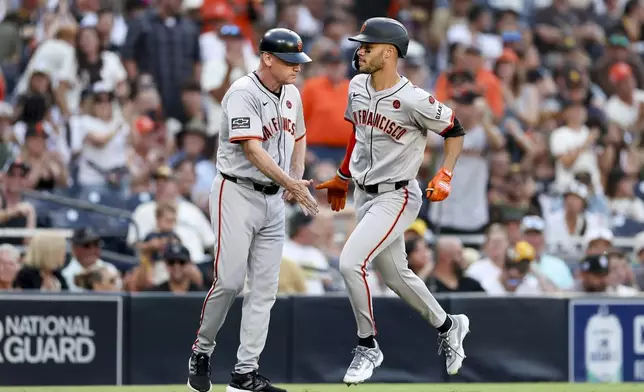 San Francisco Giants' Grant McCray, right, celebrates with third base coach Matt Williams, left, after hitting a three-run home run during the second inning of a baseball game against the San Diego Padres, Saturday, Sept. 7, 2024, in San Diego. (AP Photo/Ryan Sun)