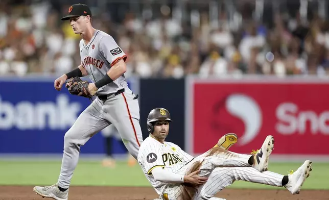 San Diego Padres' Tyler Wade, right, reacts after being forced out at second by San Francisco Giants shortstop Tyler Fitzgerald, who threw out Mason McCoy at first to complete a double play during the sixth inning of a baseball game Saturday, Sept. 7, 2024, in San Diego. (AP Photo/Ryan Sun)