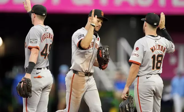 San Francisco Giants' Tyler Fitzgerald (49), Donovan Walton (18) and Grant McCray celebrate after their baseball game against the Kansas City Royals Saturday, Sept. 21, 2024, in Kansas City, Mo. The Giants won 9-0. (AP Photo/Charlie Riedel)