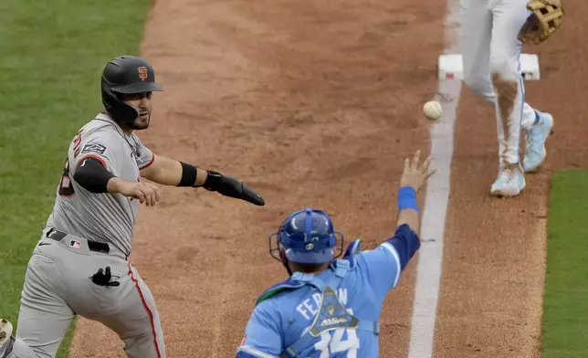 San Francisco Giants' Michael Conforto is caught between Kansas City Royals third baseman Maikel Garcia (11) and catcher Freddy Fermin (34) as he tried to score on a fielders choice hit into by Grant McCray during the sixth inning of a baseball game Saturday, Sept. 21, 2024, in Kansas City, Mo. (AP Photo/Charlie Riedel)