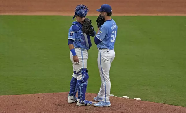 Kansas City Royals catcher Freddy Fermin and starting pitcher Brady Singer (51) meet on the mound during the sixth inning of a baseball game against the San Francisco Giants Saturday, Sept. 21, 2024, in Kansas City, Mo. (AP Photo/Charlie Riedel)