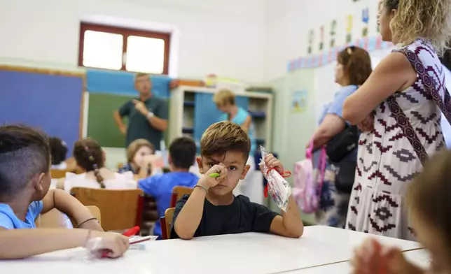 Filippos and other students attend the first day of school at a public elementary school in Athens, on Wednesday, Sept. 11, 2024. (AP Photo/Petros Giannakouris)