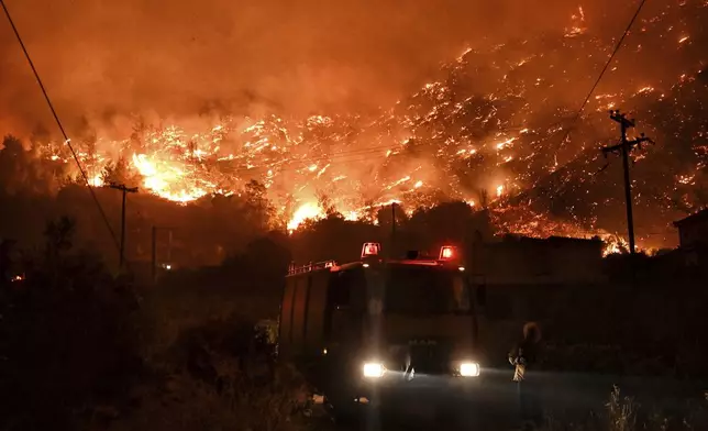 A wildfire approaches the village of Ano Loutro as fanned by strong winds raged uncontrolled despite the attempts of hundreds of firefighters to stop it, some 131 kilometers (81 miles) west of Athens, Greece, in the region of Corinthia, late Sunday, Sept. 29, 2024. (AP Photo)