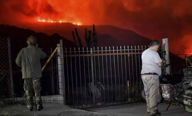 Residents watch a wildfire approaching the village of Kallithea as fanned by strong winds raged uncontrolled despite the attempts of hundreds of firefighters to stop it, some 149 kilometers (93 miles) west of Athens, Greece, in the region of Corinthia, late Sunday, Sept. 29, 2024. (AP Photo)