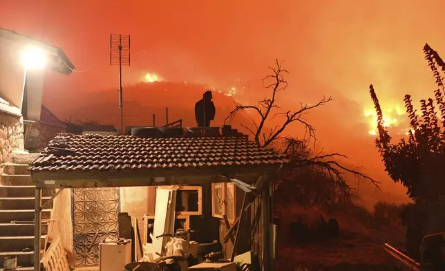 A wildfire approaches the village of Kallithea as fanned by strong winds raged uncontrolled despite the attempts of hundreds of firefighters to stop it, some 149 kilometers (93 miles) west of Athens, Greece, in the region of Corinthia, late Sunday, Sept. 29, 2024. (AP Photo)