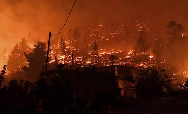 A wildfire burns a forest near the village of Kallithea as fanned by strong winds raged uncontrolled despite the attempts of hundreds of firefighters to stop it, some 149 kilometers (93 miles) west of Athens, Greece, in the region of Corinthia, late Sunday, Sept. 29, 2024. (AP Photo)