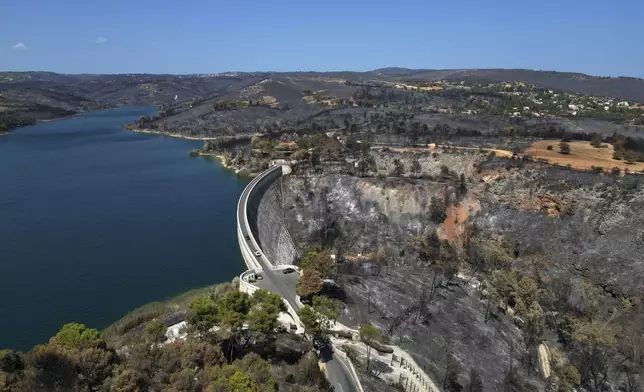 The blackened forests around Marathon Lake, which had been burned in a mid-August wildfire, are seen from above about 36 kilometres (22 miles) north of Athens, Thursday, Aug. 22, 2024. (AP Photo/Thanassis Stavrakis)