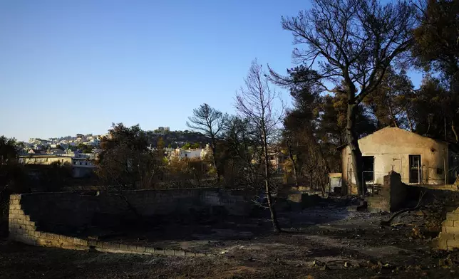 A damaged house, which had been burned in a mid-August wildfire, is seen in Halandri suburb in northern Athens, Sunday, Aug. 25, 2024. (AP Photo/Thanassis Stavrakis)