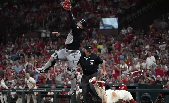 St. Louis Cardinals' Masyn Winn, right, scores past Cleveland Guardians catcher Bo Naylor during the seventh inning of a baseball game Saturday, Sept. 21, 2024, in St. Louis. (AP Photo/Jeff Roberson)