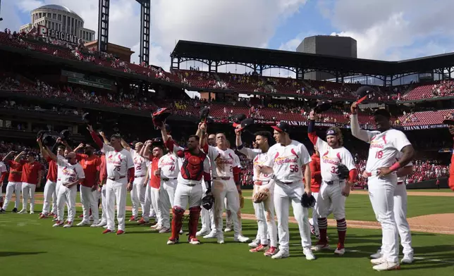 Members of the St. Louis Cardinals salute fans following a baseball game against the Cleveland Guardians, the Cardinals final home game of the season, Sunday, Sept. 22, 2024, in St. Louis. (AP Photo/Jeff Roberson)