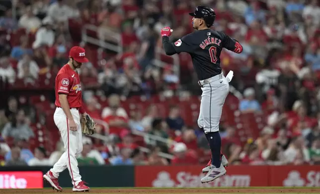 Cleveland Guardians' Andres Gimenez (0) celebrates as he rounds the bases past St. Louis Cardinals third baseman Thomas Saggese after hitting a solo home run during the sixth inning of a baseball game Friday, Sept. 20, 2024, in St. Louis. (AP Photo/Jeff Roberson)