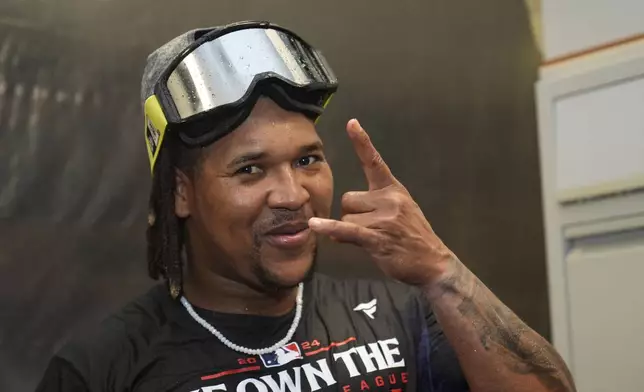 Cleveland Guardians' Jose Ramirez celebrates with teammates in the clubhouse after winning the American League Central following a baseball game against the St. Louis Cardinals Saturday, Sept. 21, 2024, in St. Louis. (AP Photo/Jeff Roberson)