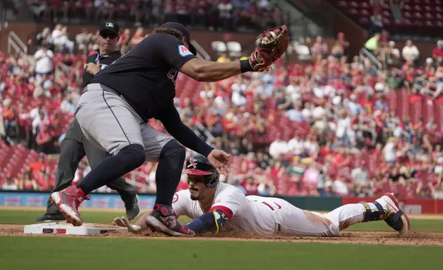 St. Louis Cardinals' Nolan Arenado, right, dives back to first ahead of the tag from Cleveland Guardians first baseman Josh Naylor after hitting an RBI single during the sixth inning of a baseball game Sunday, Sept. 22, 2024, in St. Louis. (AP Photo/Jeff Roberson)