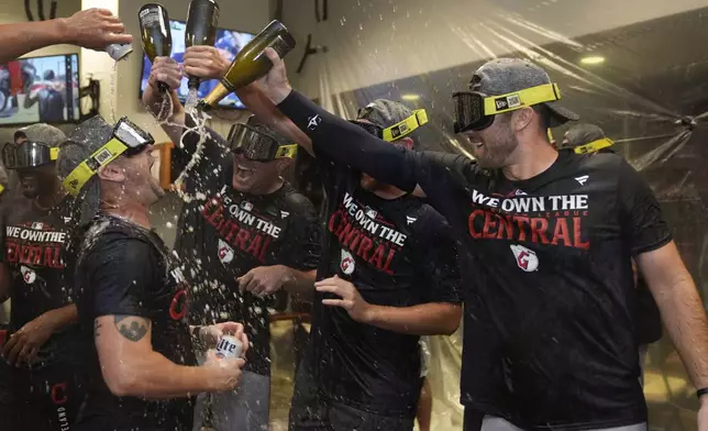 Members of the Cleveland Guardians celebrate winning the American League Central following a baseball game against the St. Louis Cardinals Saturday, Sept. 21, 2024, in St. Louis. (AP Photo/Jeff Roberson)