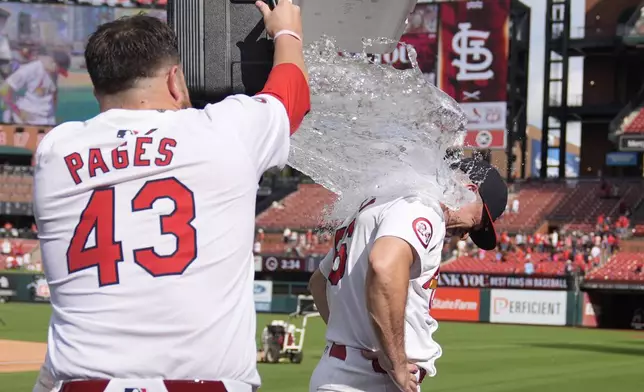 St. Louis Cardinals relief pitcher Ryan Helsley, right, is doused by teammate Pedro Pages (43) following a baseball game against the Cleveland Guardians Sunday, Sept. 22, 2024, in St. Louis. (AP Photo/Jeff Roberson)