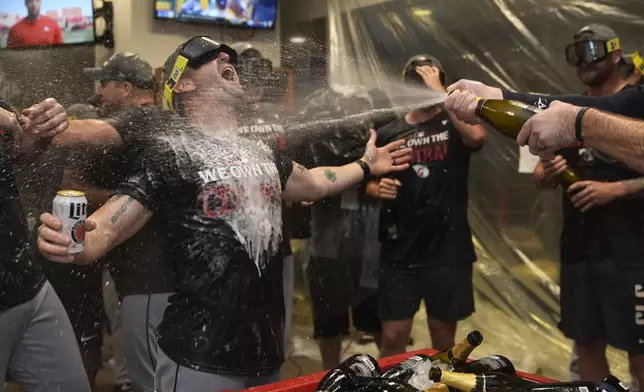 Members of the Cleveland Guardians celebrate winning the American League Central following a baseball game against the St. Louis Cardinals Saturday, Sept. 21, 2024, in St. Louis. (AP Photo/Jeff Roberson)