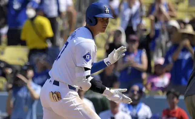 Los Angeles Dodgers' Shohei Ohtani scores after hitting a solo home run during the fifth inning of a baseball game against the Cleveland Guardians, Sunday, Sept. 8, 2024, in Los Angeles. (AP Photo/Mark J. Terrill)