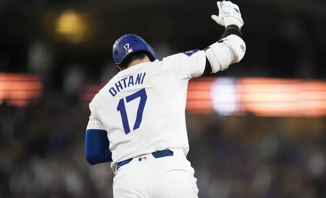 Los Angeles Dodgers designated hitter Shohei Ohtani (17) reacts after hitting a home run during the sixth inning of a baseball game against the Cleveland Guardians in Los Angeles, Friday, Sept. 6, 2024. (AP Photo/Ashley Landis)