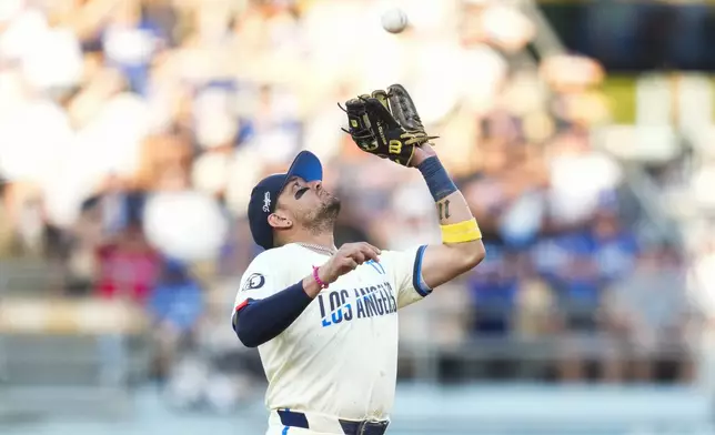 Los Angeles Dodgers shortstop Miguel Rojas catches a fly ball hit by Cleveland Guardians' José Ramírez during the first inning of a baseball game in Los Angeles, Saturday, Sept. 7, 2024. (AP Photo/Ashley Landis)