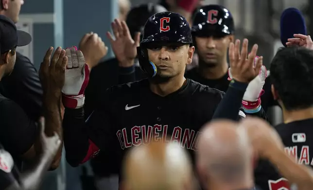 Cleveland Guardians' Andrés Giménez celebrates in the dugout after hitting a home run during the sixth inning of a baseball game against the Los Angeles Dodgers in Los Angeles, Friday, Sept. 6, 2024. Brayan Rocchio also scored. (AP Photo/Ashley Landis)