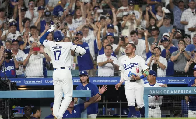 Los Angeles Dodgers designated hitter Shohei Ohtani (17) celebrates with Miguel Rojas (11) after hitting a home run during the sixth inning of a baseball game against the Cleveland Guardians in Los Angeles, Friday, Sept. 6, 2024. (AP Photo/Ashley Landis)