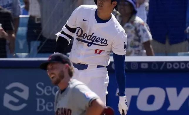 Los Angeles Dodgers' Shohei Ohtani, top, watches along with Cleveland Guardians starting pitcher Tanner Bibee as his ball goes out for a solo home run during the fifth inning of a baseball game, Sunday, Sept. 8, 2024, in Los Angeles. (AP Photo/Mark J. Terrill)