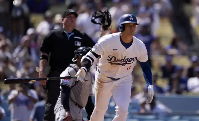 Los Angeles Dodgers' Shohei Ohtani, right, heads to first for a solo home run as Cleveland Guardians catcher Bo Naylor, center, and home plate umpire Dan Bellino watch during the fifth inning of a baseball game, Sunday, Sept. 8, 2024, in Los Angeles. (AP Photo/Mark J. Terrill)