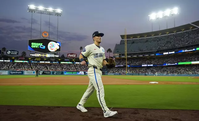 Los Angeles Dodgers center fielder Tommy Edman returns to the dugout after the second inning of a baseball game against the Cleveland Guardians in Los Angeles, Saturday, Sept. 7, 2024. (AP Photo/Ashley Landis)