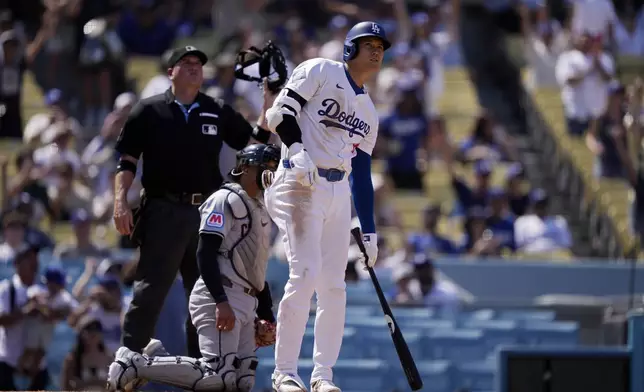 Los Angeles Dodgers' Shohei Ohtani, right, watches as his ball goes out for a solo home run as Cleveland Guardians catcher Bo Naylor, center, and home plate umpire Dan Bellino watch as well during the fifth inning of a baseball game, Sunday, Sept. 8, 2024, in Los Angeles. (AP Photo/Mark J. Terrill)