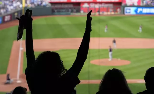 Fans stand for the seventh inning stretch during a baseball game between the Kansas City Royals and the Cleveland Guardians Monday, Sept. 2, 2024, in Kansas City, Mo. (AP Photo/Charlie Riedel)