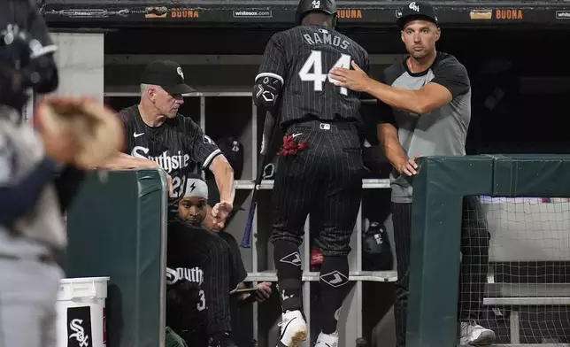 Chicago White Sox interim manager Grady Sizemore, right, pats designated hitter Bryan Ramos (44) on the back after Ramos was struck out by the Cleveland Guardians during the third inning of a baseball game Monday, Sept. 9, 2024, in Chicago. (AP Photo/Erin Hooley)