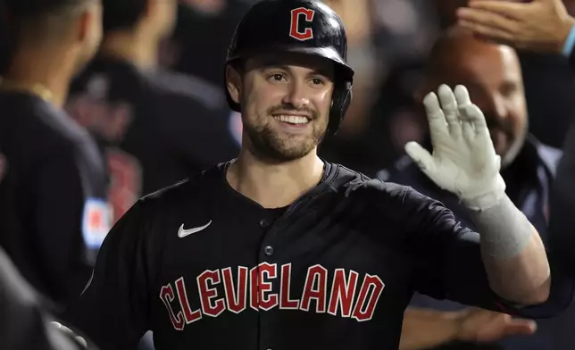 Cleveland Guardians' Lane Thomas celebrates in the dugout after hitting a three-run home run during the sixth inning of a baseball game against the Chicago White Sox Tuesday, Sept. 10, 2024, in Chicago. (AP Photo/Melissa Tamez)