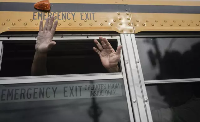 Nicaraguan citizens wave from a bus after being released from a Nicaraguan jail and landing at the airport in Guatemala City, Thursday, Sept. 5, 2024. (AP Photo/Moises Castillo)