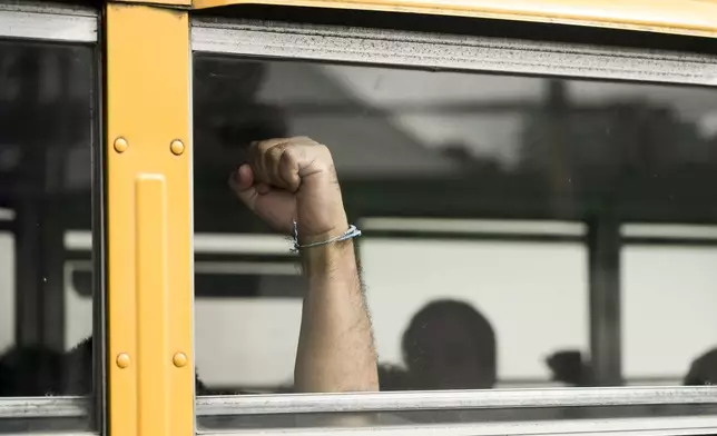 A Nicaraguan citizen raises his fist from a bus after being released from a Nicaraguan jail and landing at the airport in Guatemala City, Thursday, Sept. 5, 2024. (AP Photo/Moises Castillo)