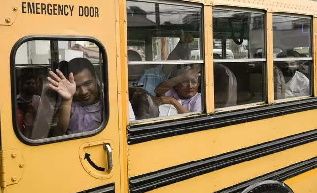 Nicaraguan citizens wave from a bus after being released from a Nicaraguan jail and landing at the airport in Guatemala City, Thursday, Sept. 5, 2024. (AP Photo/Moises Castillo)