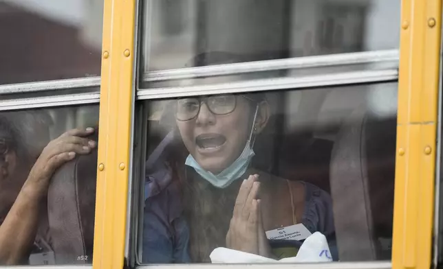 Lucia Garcia gestures from a bus after being released from a Nicaraguan jail and landing at the airport in Guatemala City, Thursday, Sept. 5, 2024. (AP Photo/Moises Castillo)