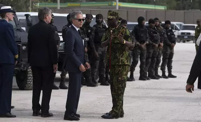 U.S. Secretary of State Antony Blinken, in sunglasses, speaks with Commander of the Multinational Security Support Mission Commander Godfrey Otunge in Port-au-Prince, Haiti, Thursday, Sept. 5, 2024. (Roberto Schmidt/Pool photo via AP)