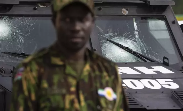 A Kenyan member of the Multinational Security Support (MSS) mission stands next to a Haitian police vehicle donated by the U.S. government and damaged by bullet hits during patrols, in Port-au-Prince, Haiti, Thursday, Sept. 5, 2024. (Roberto Schmidt/Pool photo via AP)