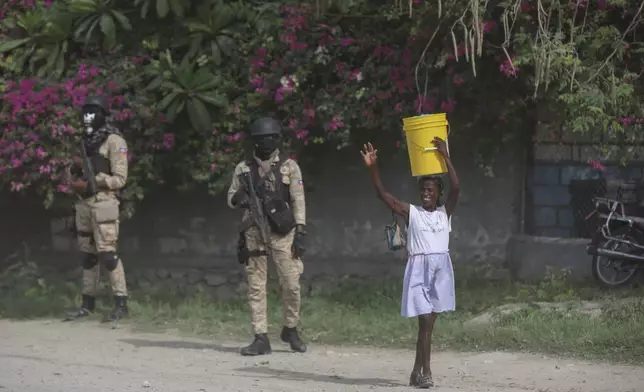 A street vendor walks past police officers ahead of the arrival of U.S. Secretary of State Antony Blinken in Port-au-Prince, Haiti, Thursday, Sept. 5, 2024. (AP Photo/Odelyn Joseph)