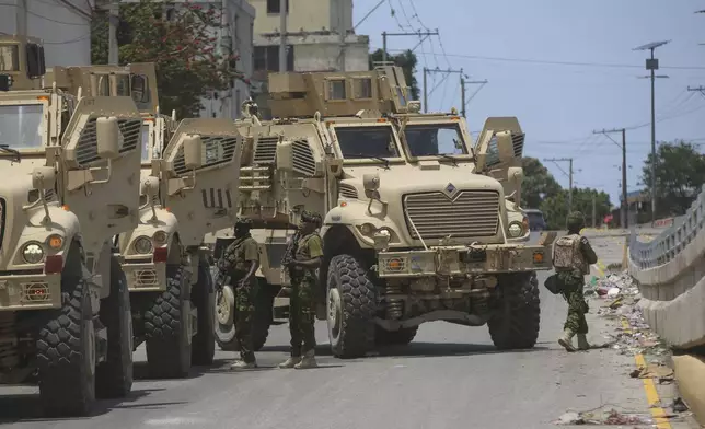 Kenyan police officers, part of a UN-backed multinational, work to tow away a broken down armored car during an operation in the Delmas neighborhood of Port-au-Prince, Haiti, Wednesday, Sept. 4, 2024. (AP Photo/Odelyn Joseph)