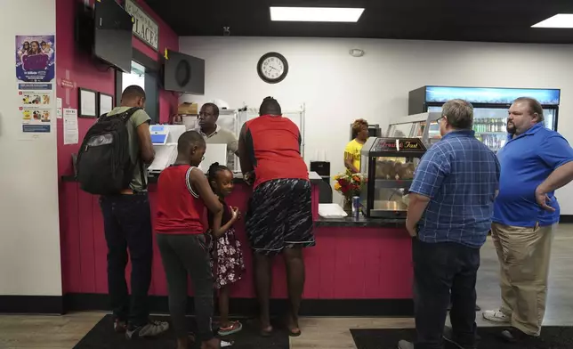 Romane Pierre of Rose Goute Creole Restaurant in Springfield, Ohio, helps a line of customers, Monday, Sept. 16, 2024. (AP Photo/Jessie Wardarski)