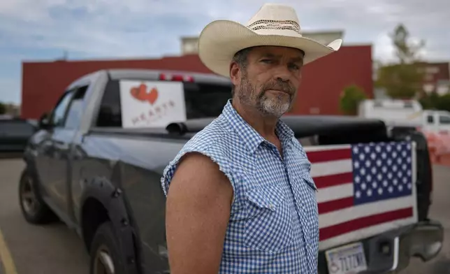 Cowboy David Graham, of Newark, Ohio, on hand with a message of support, stands near his truck across the street from City Hall, Tuesday, Sept. 17, 2024, in Springfield, Ohio. (AP Photo/Carolyn Kaster)