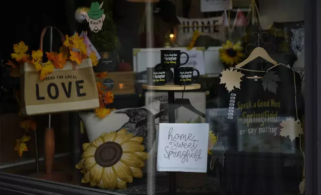 Items supporting Springfield, Ohio, including the slogan "Speak a Good Word for Springfield or say nothing," and "Hope Sweet Springfield," are displayed in the Champion City Guide &amp; Supply shop window, Tuesday, Sept. 17, 2024, in Springfield, Ohio. (AP Photo/Carolyn Kaster)